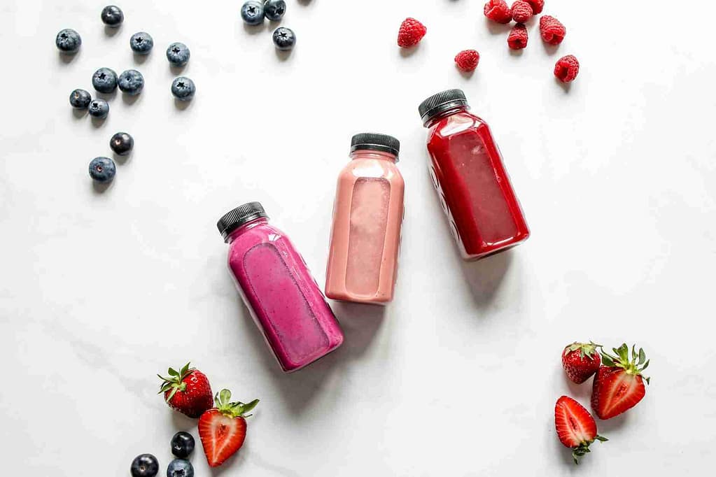 healthy smoothie recipes for weight loss:three bottles of smoothie beside berries